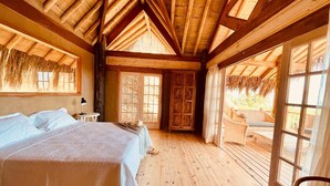 Une pièce en bois avec un lit, une petite table et une fenêtre.
