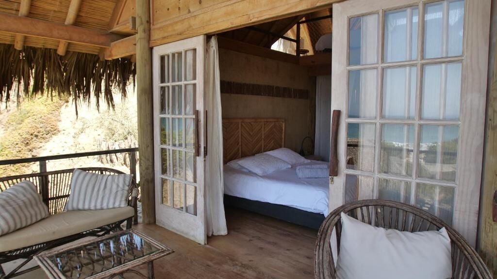 Une pièce en bois avec un lit, un canapé et une table en verre.