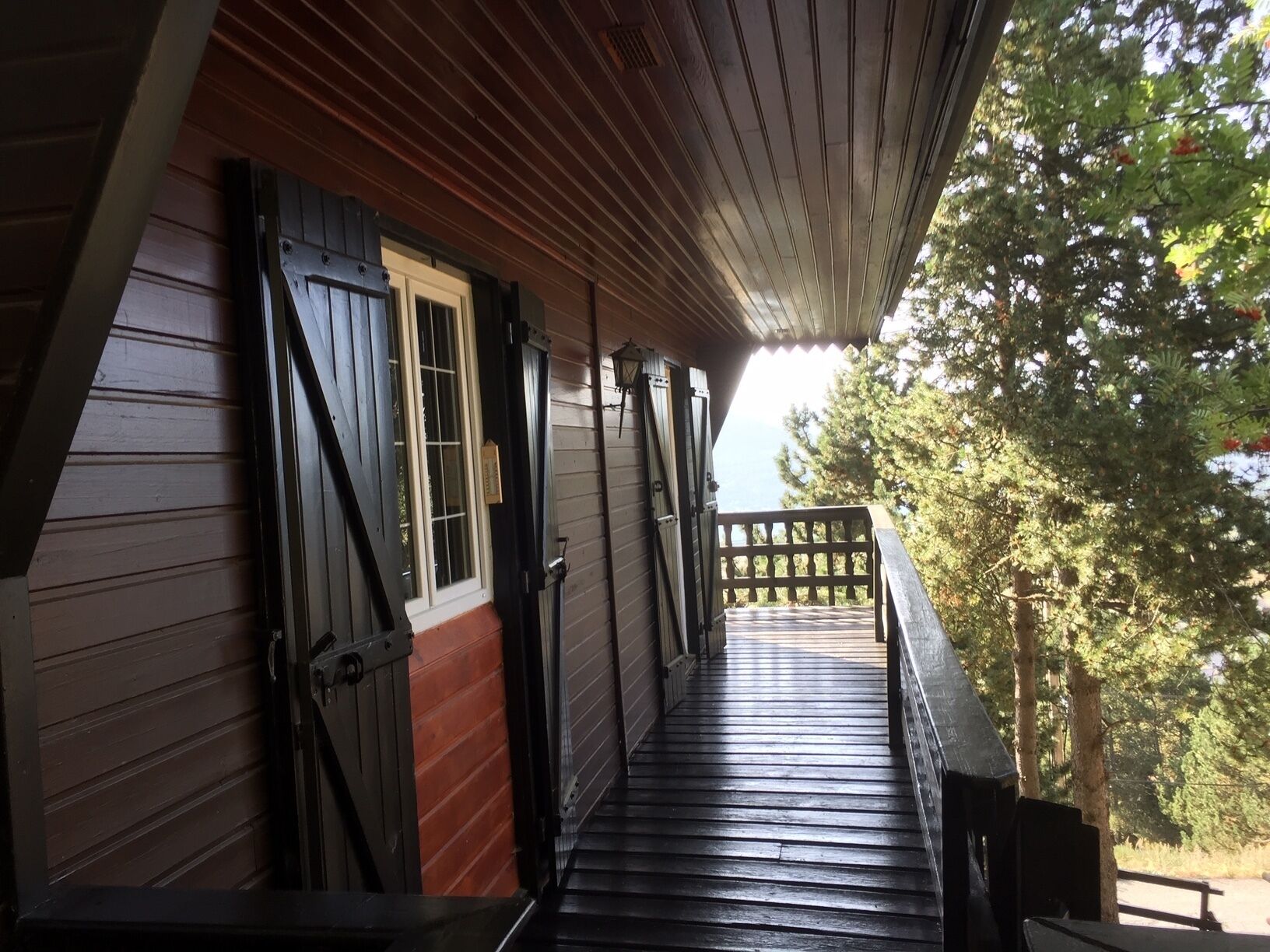 A wooden porch with a wooden floor and a railing.