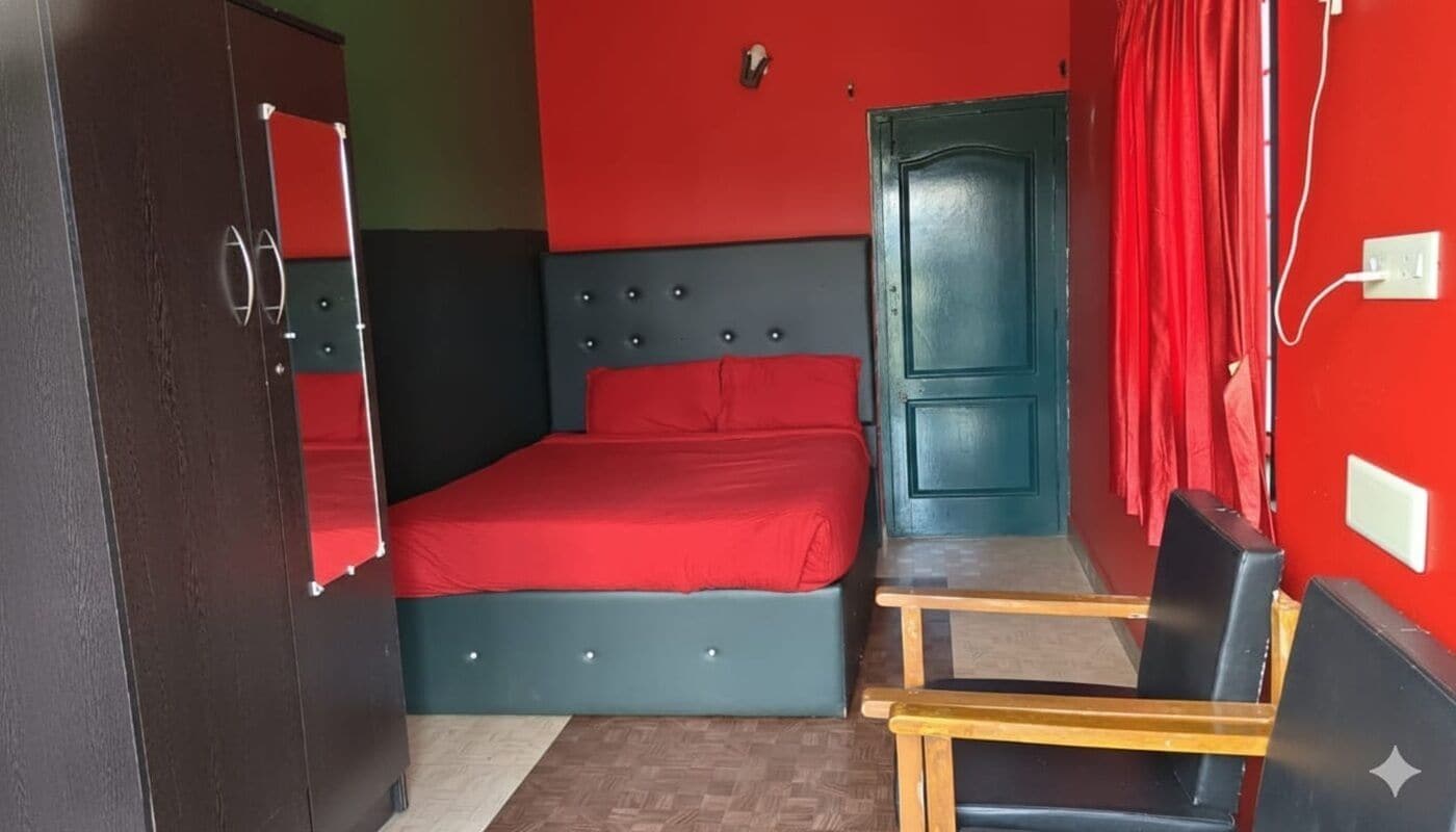 A room with a bed, a chair, a wardrobe, and a door.