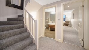A staircase leading to a bathroom with a mirror, a sink, and a towel rack. -  Executive Apartments in Central London Euston FREE WiFi by City Stay Aparts (London)