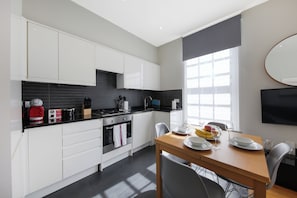 Executive appartement | Privékeuken | Een koelkast met diepvriezer, een microgolfoven, een oven, een kookplaat