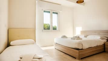 Un dormitorio con dos camas, una ventana con vistas y una lámpara colgante.