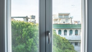 A room with two windows overlooking a building and greenery. - Condominio Villa Mauro (Jesolo)