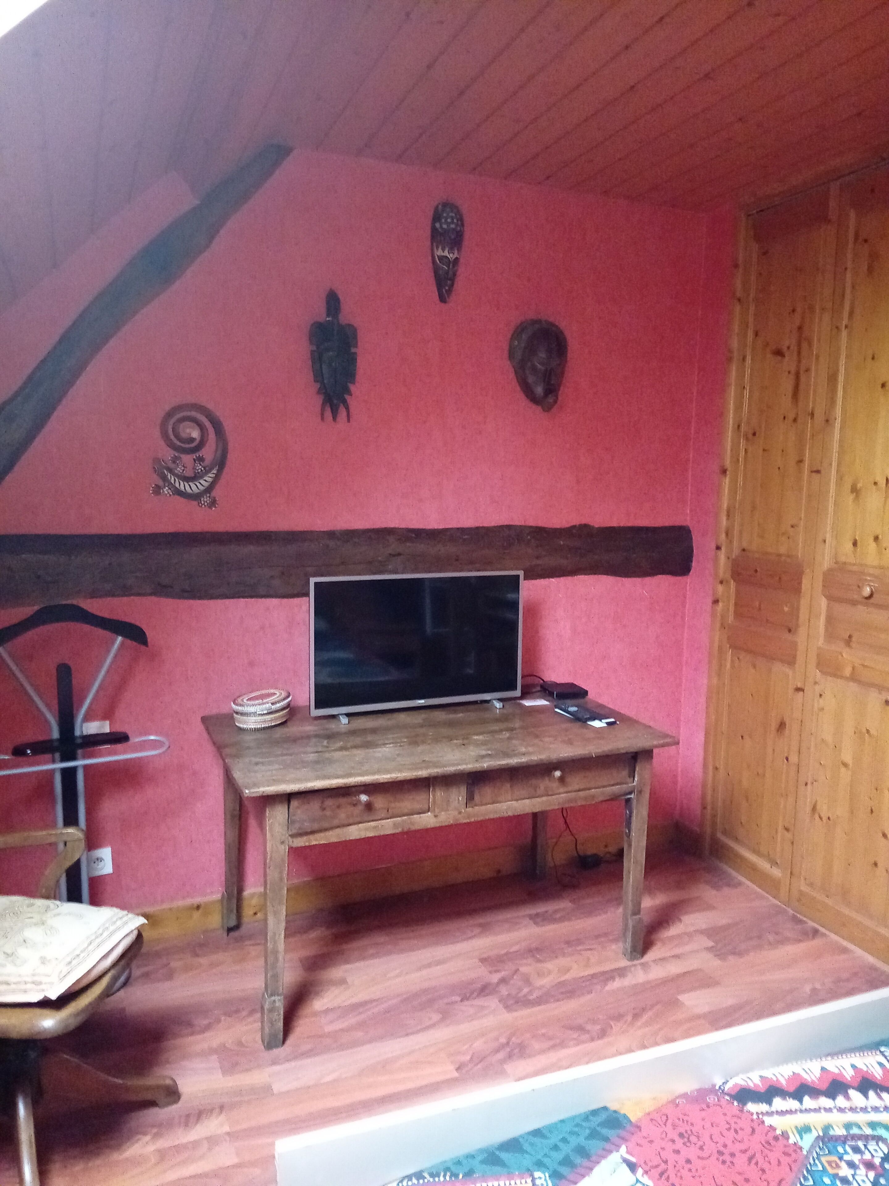 Een kamer met een houten tafel, een televisie en een stoel.
