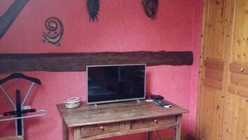 Een kamer met een houten tafel, een televisie en een stoel.