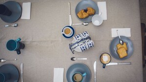 Una mesa servida con platos, vasos y cubiertos, lista para una comida.