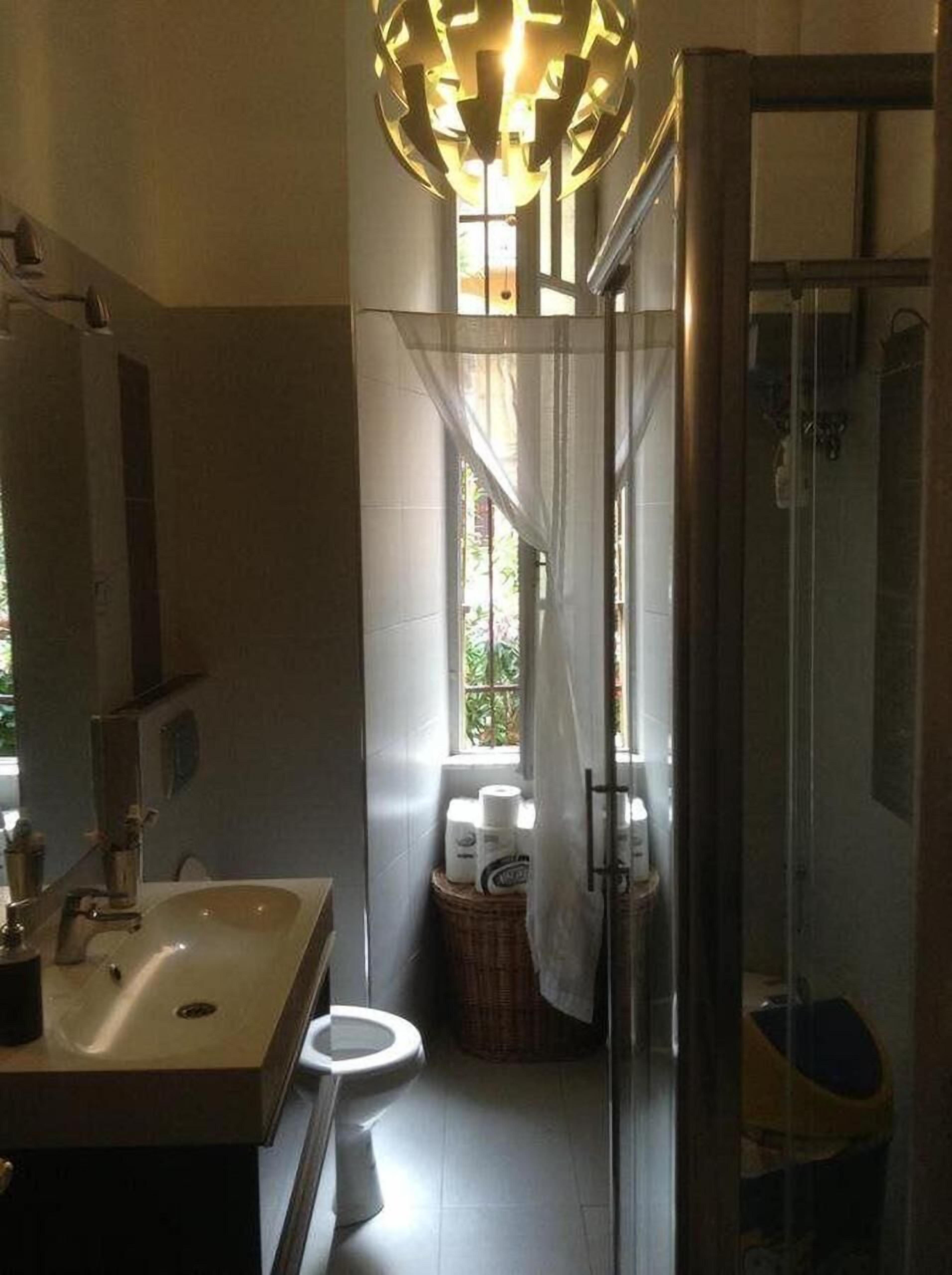 A bathroom with a sink, toilet, and shower area.