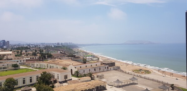 Un paisaje urbano costero con playa, edificios y cielo despejado.