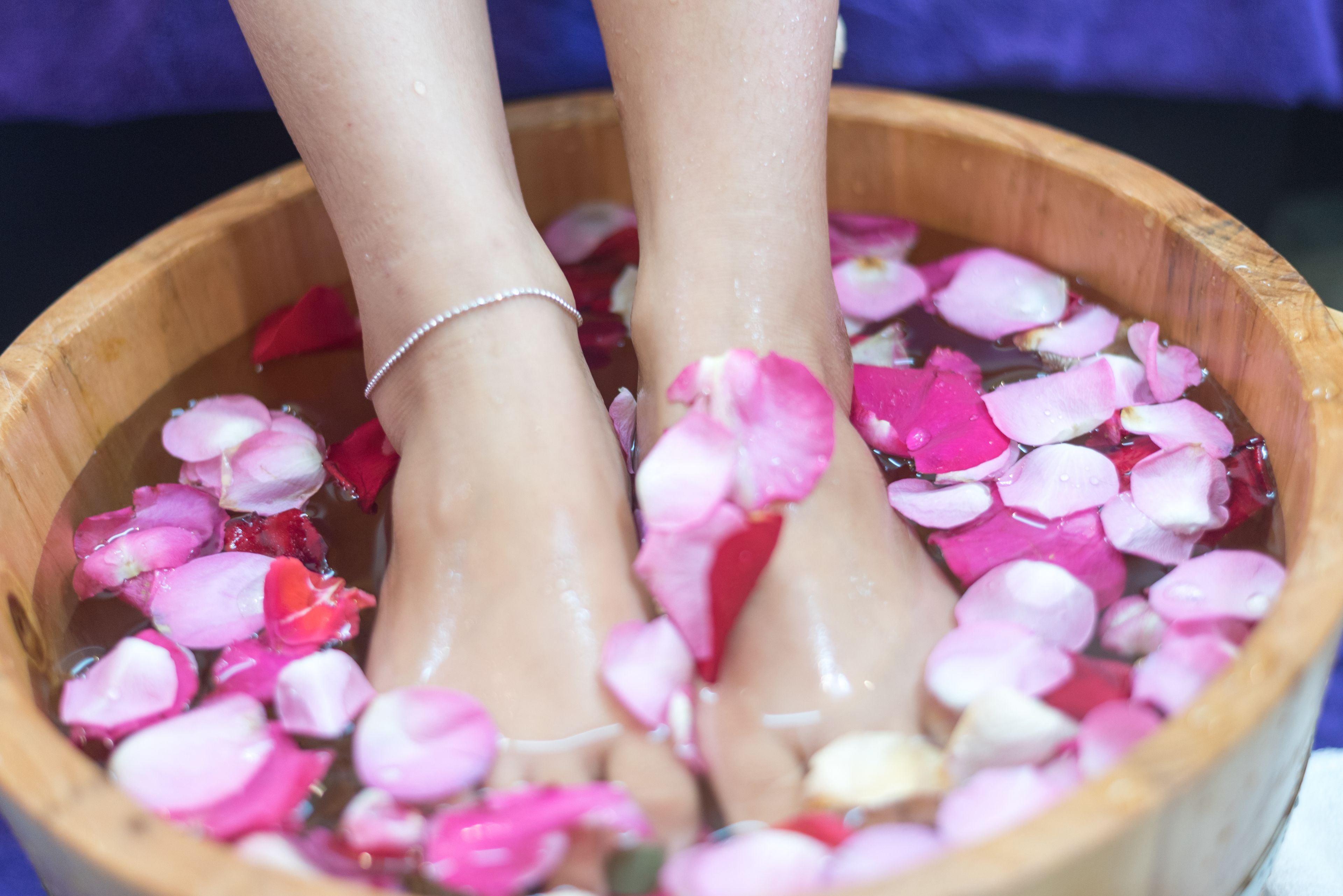 A wooden basin filled with water and rose petals.