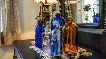 A table with various glass bottles and a lamp.