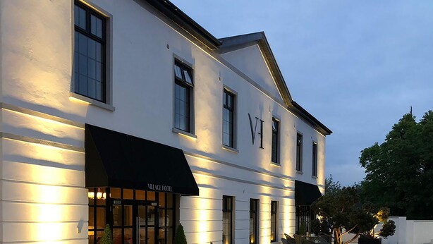 A modern building with a black awning labeled "VIAGE HOTEL" and a well-lit entrance. - Village Hotel (Bettystown)