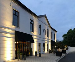 Un edificio moderno con un toldo negro que dice "VIAGE HOTEL" y una entrada bien iluminada.