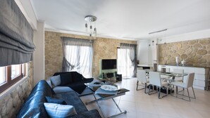 Un salon moderne comprenant un canapé, une table à manger et un coin cuisine.