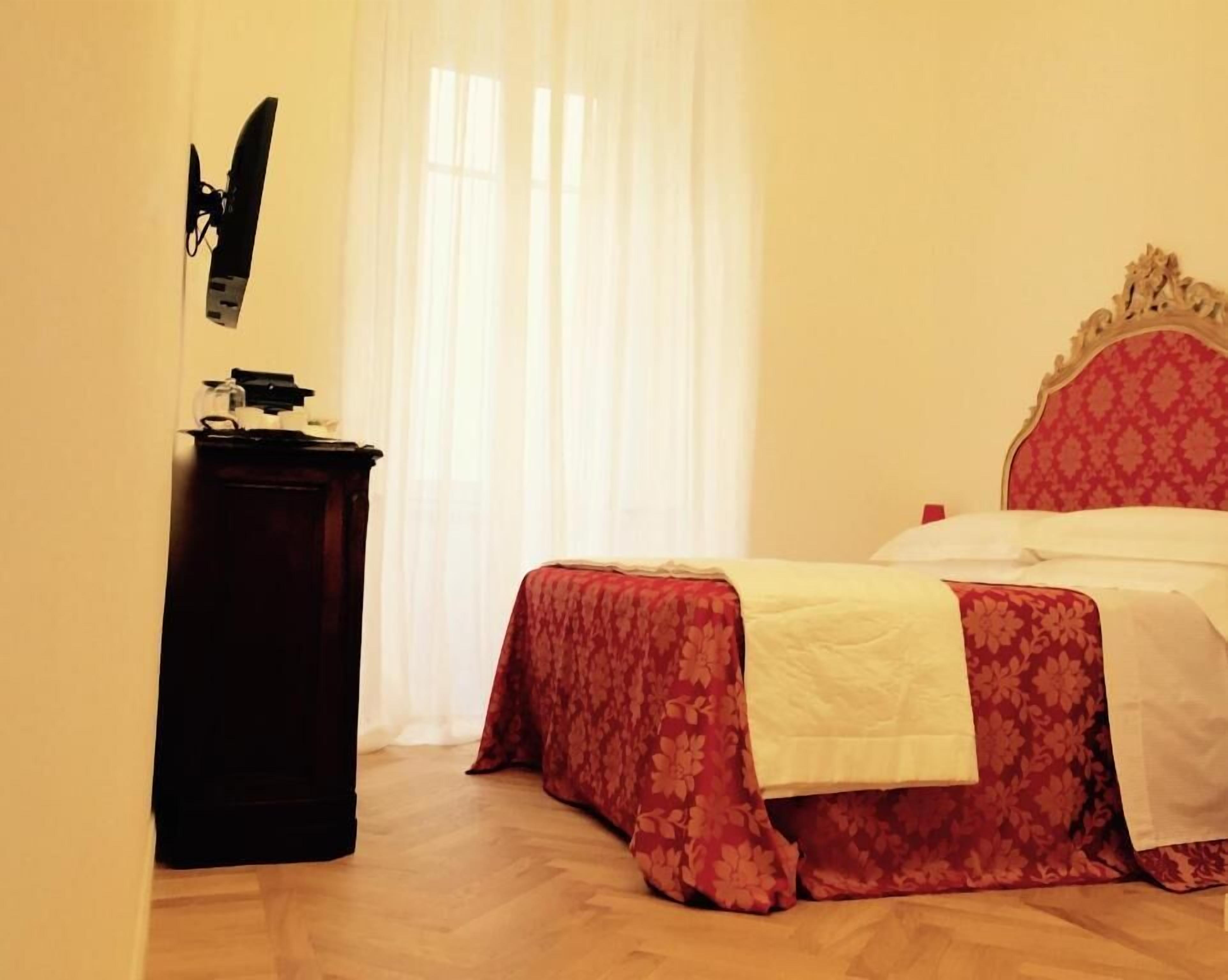 Une chambre à coucher avec un lit, une table de chevet et une fenêtre avec des rideaux.