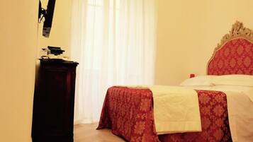 Une chambre à coucher avec un lit, une table de chevet et une fenêtre avec des rideaux.