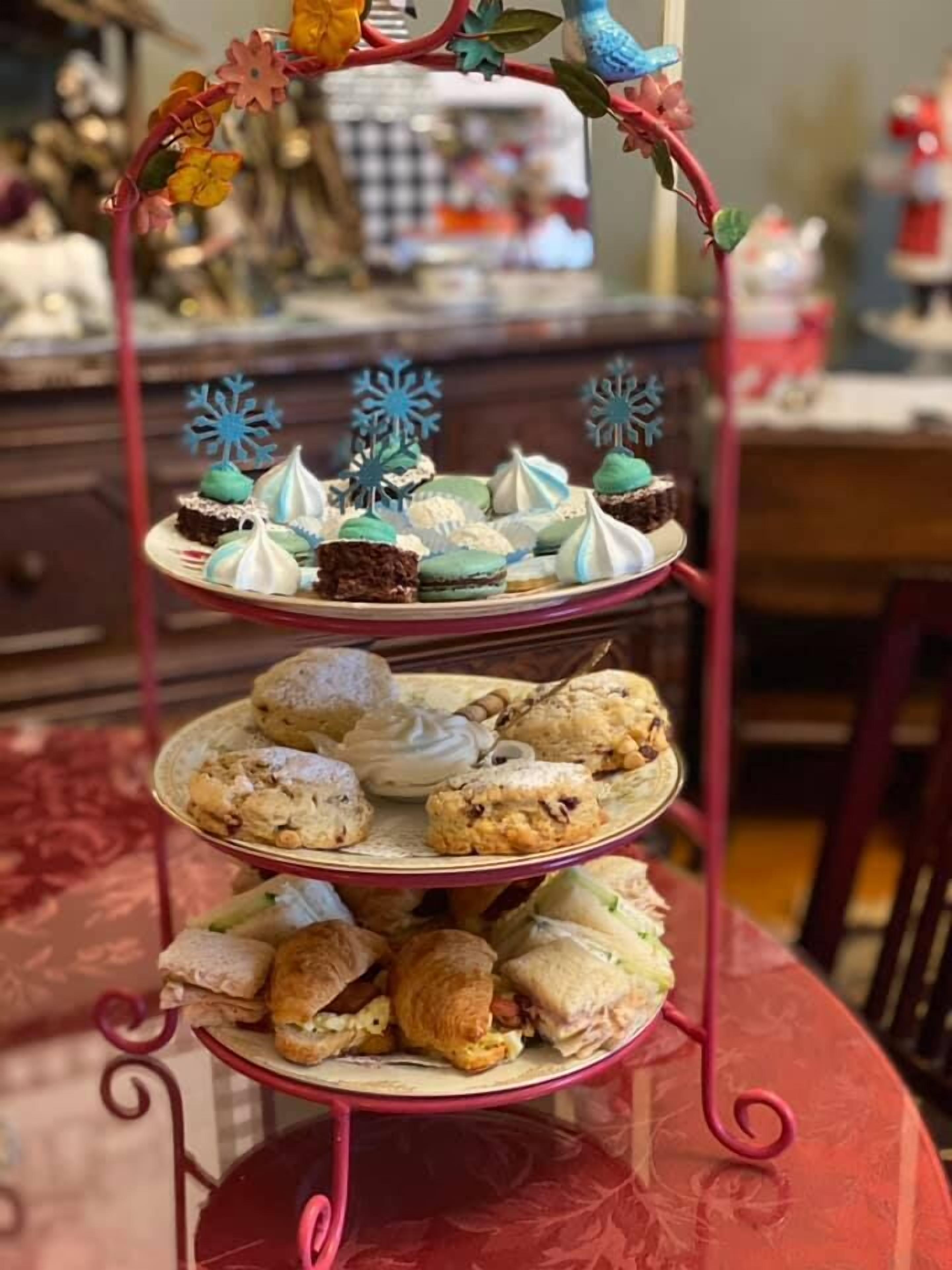 A three-tiered dessert stand with various pastries and cookies.