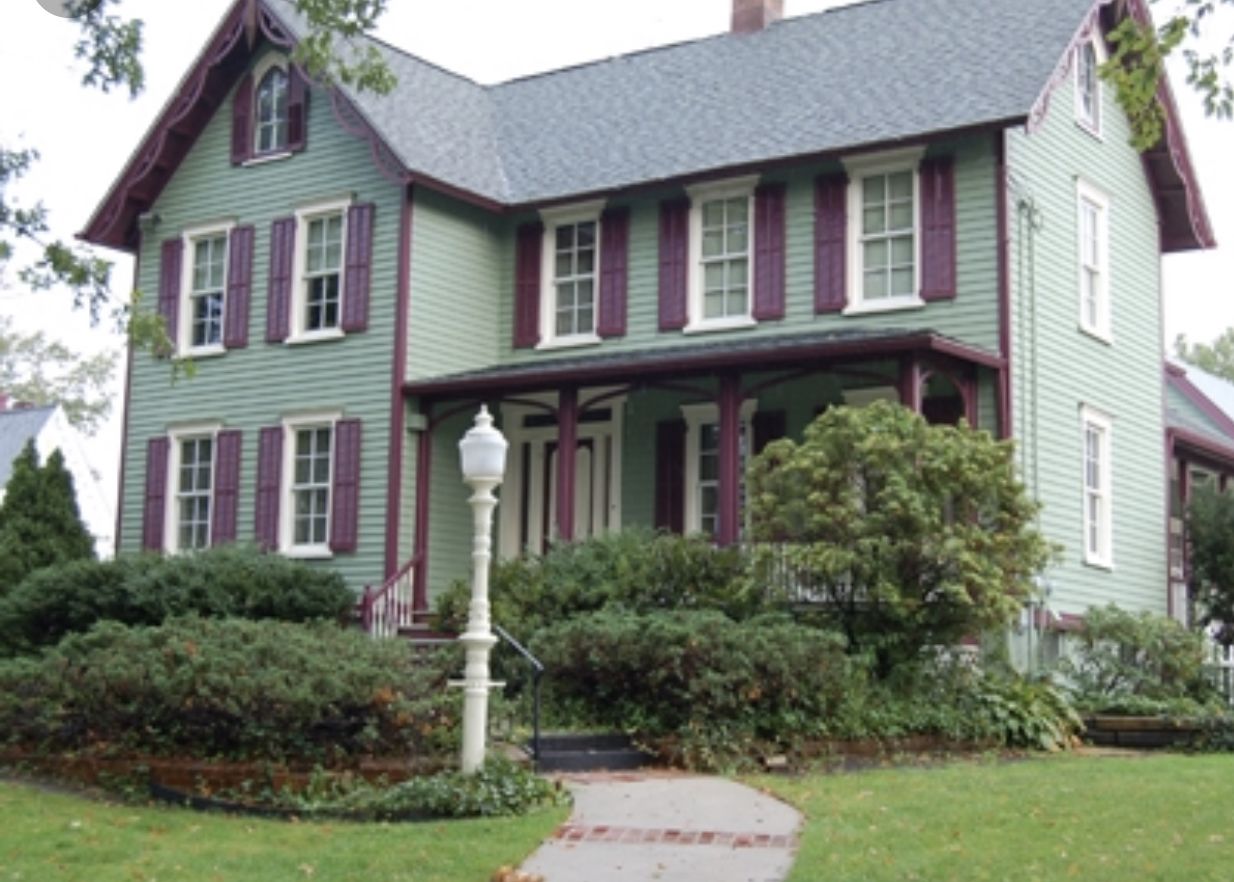 A two-story house with a green exterior and red trim.