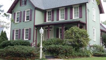 A two-story house with a green exterior and red trim.