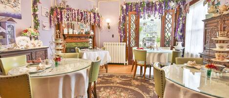 Une salle à manger avec des tables rondes, des chaises et un arrangement floral.
