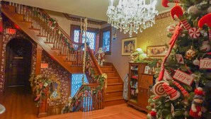 A staircase with a wooden railing, decorated with garlands and a chandelier.
