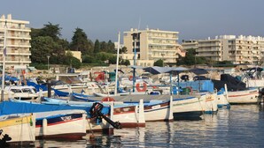 Un port de plaisance où sont amarrés de nombreux bateaux, entouré de bâtiments et d’arbres.