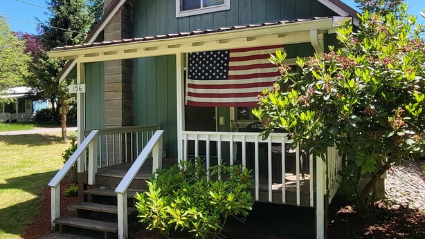 Une maison avec un porche, un drapeau et une boîte aux lettres.