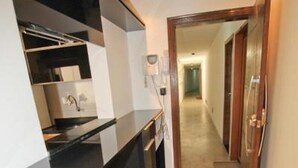 A modern kitchen with a black countertop, wooden cabinetry, and a white bench. - Apartments Almirante Gonçalves (Rio de Janeiro)