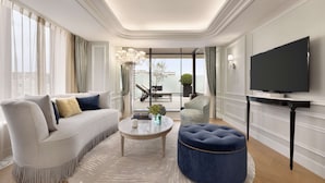 A modern living room with a sofa, ottoman, coffee table, and a flat-screen TV. - Hyatt Regency Tokyo Bay (Urayasu)