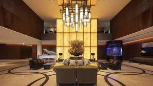 A spacious lobby with a grand piano, a large floral arrangement, and a modern chandelier. - Hyatt Regency Tokyo Bay (Urayasu)