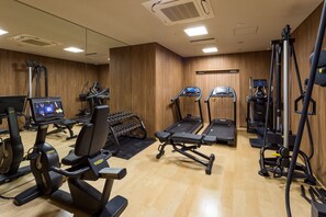 A gym with various exercise equipment including treadmills, elliptical machines, and weight machines.