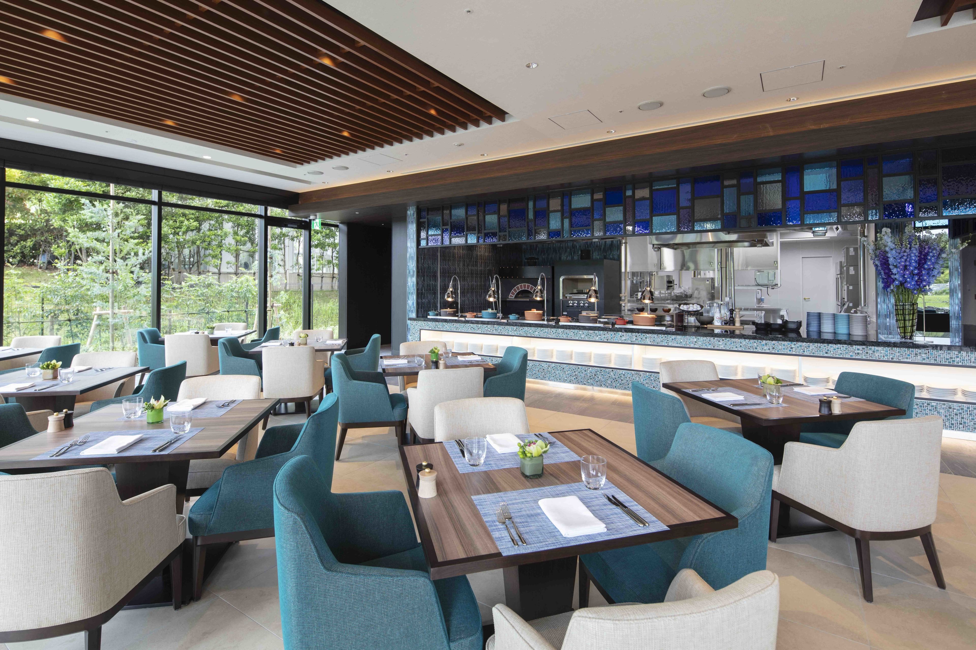 A modern restaurant with tables and chairs arranged for dining.