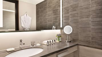 A modern bathroom with a large sink, a mirror, and a towel rack.