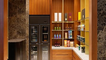 Uma cozinha moderna com frigorífico embutido, armários de madeira e painel de parede de mármore.