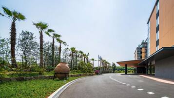 A curved road leading to a modern building with a flat roof and large windows.