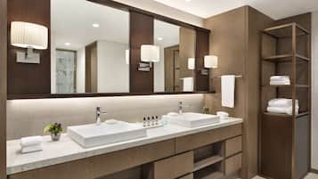 A modern bathroom with two sinks, a large mirror, and wooden shelving.