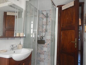 Regadera, secadora de cabello, bidet, papel de baño 