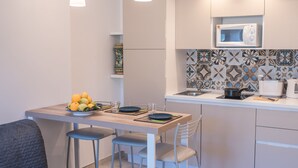 Een moderne keuken met een eethoek, inclusief een gedekte tafel, een fruitschaal en een magnetron.