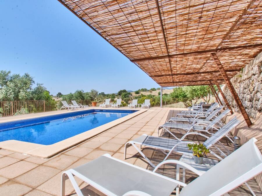 Una piscina al aire libre, sillones reclinables de piscina