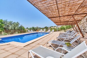 Una piscina al aire libre, tumbonas
