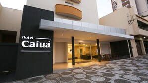 Das Hotel Caiuá mit moderner Architektur, das eine markante Eingangshalle und ein gemustertes Parkett zeigt.