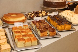 Variedad de postres a la vista, incluyendo un pastel con glaseado de caramelo, un pastel cubierto de chocolate y una tarta con rodajas de plátano.