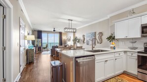A modern kitchen with white cabinets, stainless steel appliances, and a large island with a sink.