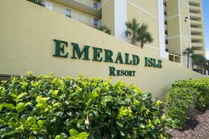 Welcome to Emerald Isle Resort, where lush greenery surrounds the elegant exterior.