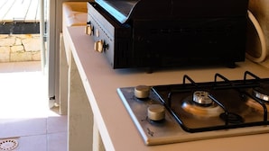 A kitchen with a gas stove, a built-in oven, and a grill.