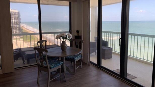 A balcony with a view of the beach and ocean.