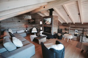 Una sala de estar acogedora con chimenea, un sofá y un televisor.