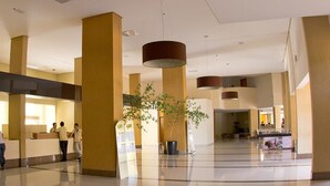 Eine großzügige Lobby mit hohen Decken, markanten Säulen und einem Empfangstresen.