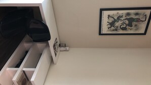 A white wall with a framed artwork depicting a bird and a ship. - The Ultimate Vacation Spot! Modern at the same time! (Houston)