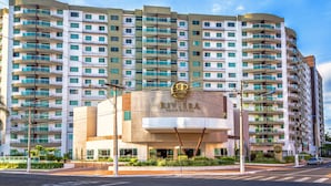 A multi-story hotel with a prominent entrance, balconies, and a clear sky. - Riviera Park Thermas - Oferta Caldas (Caldas Novas)